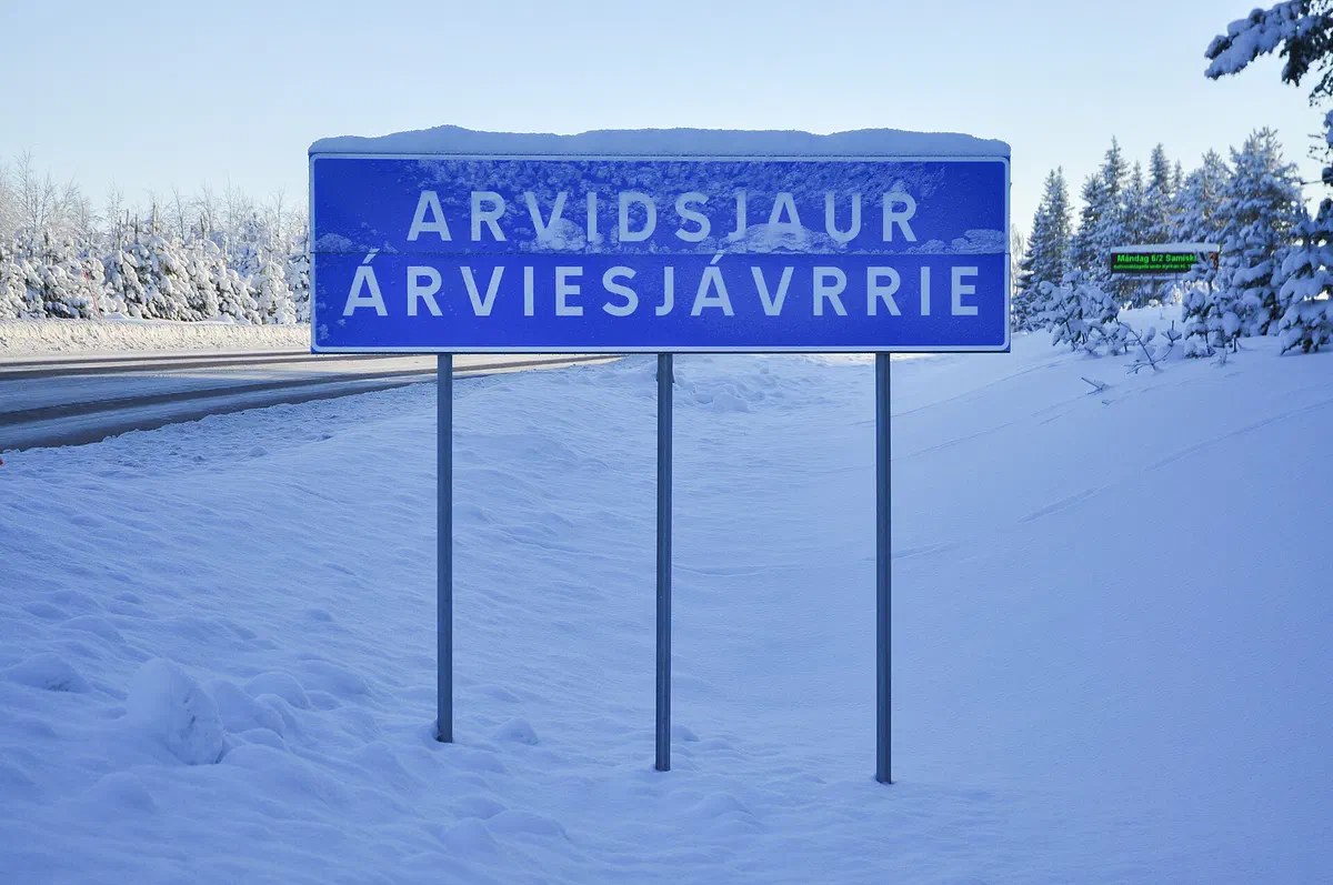 Ortsskylten Arvidsjaur – Árviesjávrrie i snö