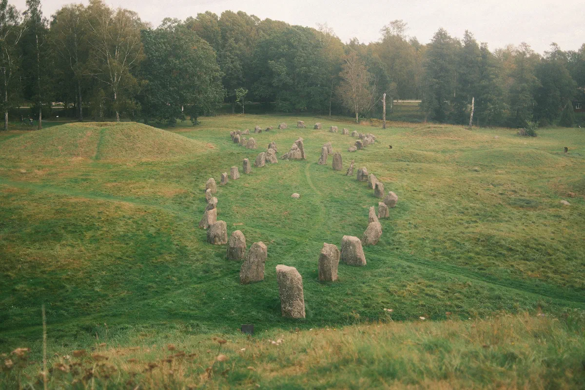 Anundshög i Badelunda, med resta stenar i förgrunden.